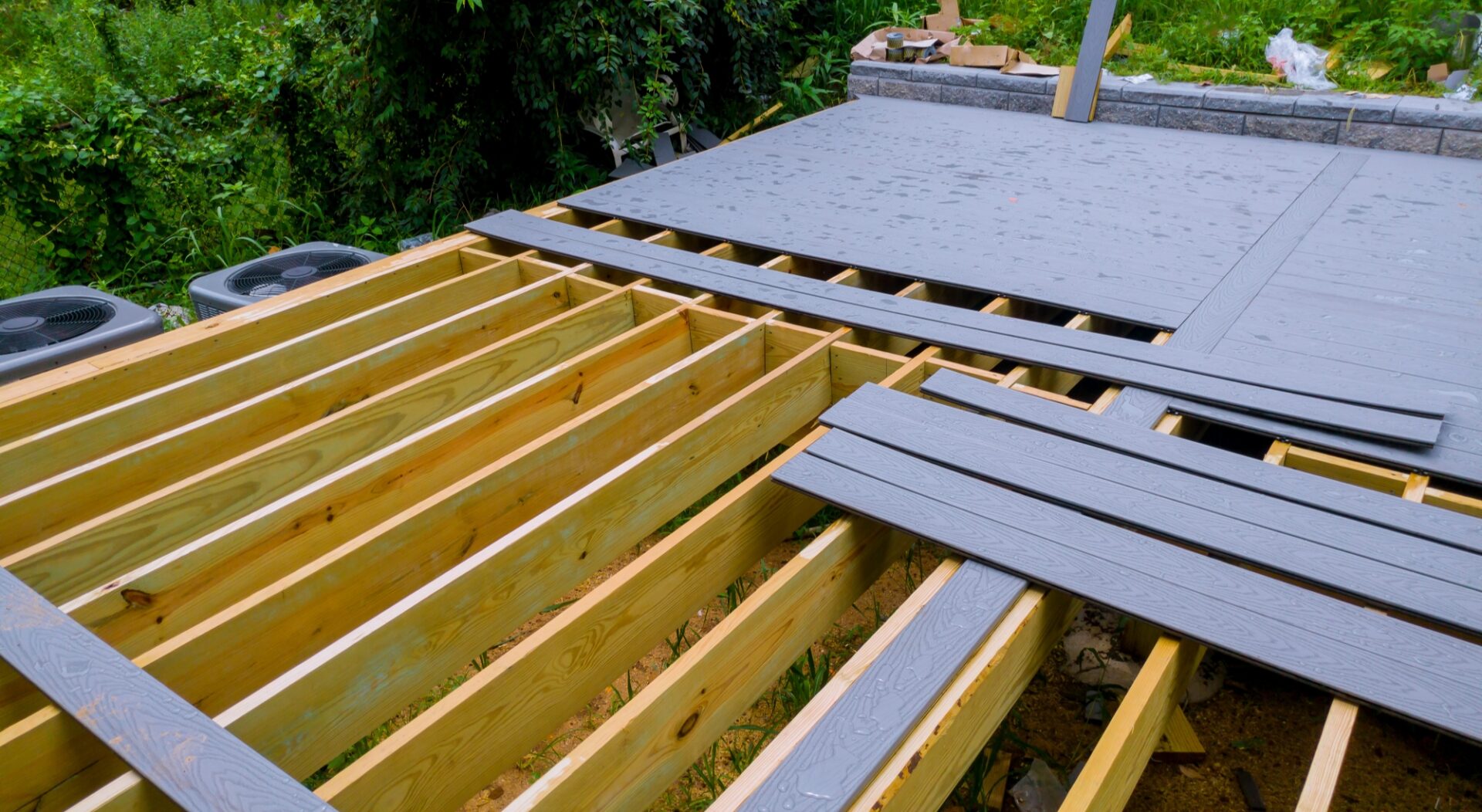 A premium deck under construction, showing joists and gray deck planks.