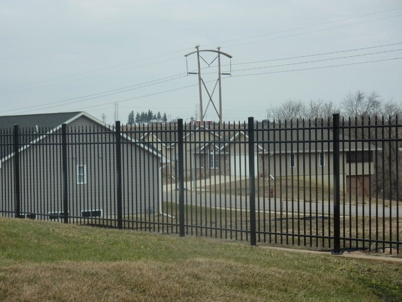 A closeup of an aluminum fence in a wrought iron style.