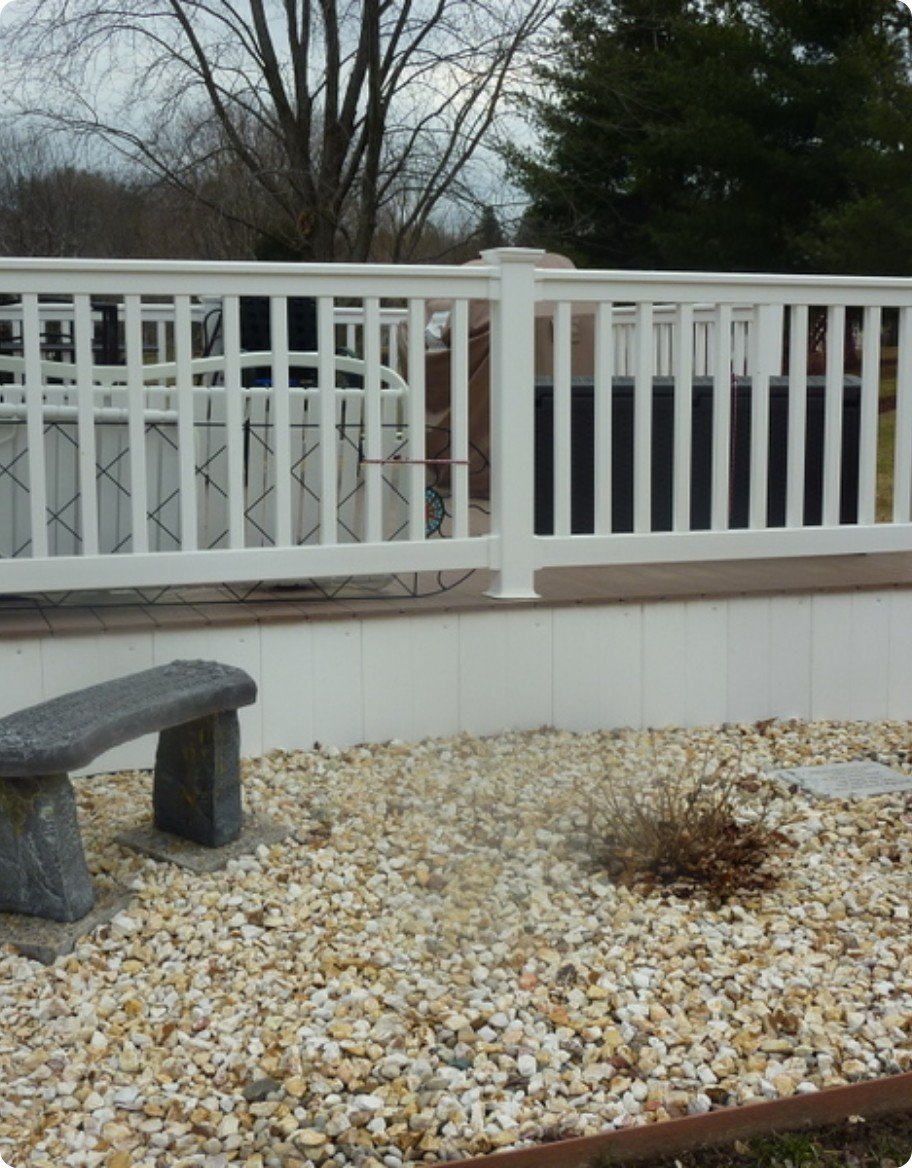 A brown deck with white vinyl railing in a traditional style.