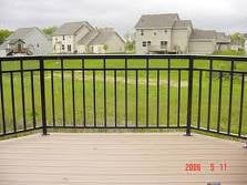 A tan deck with black aluminum railings in a wrought iron style.