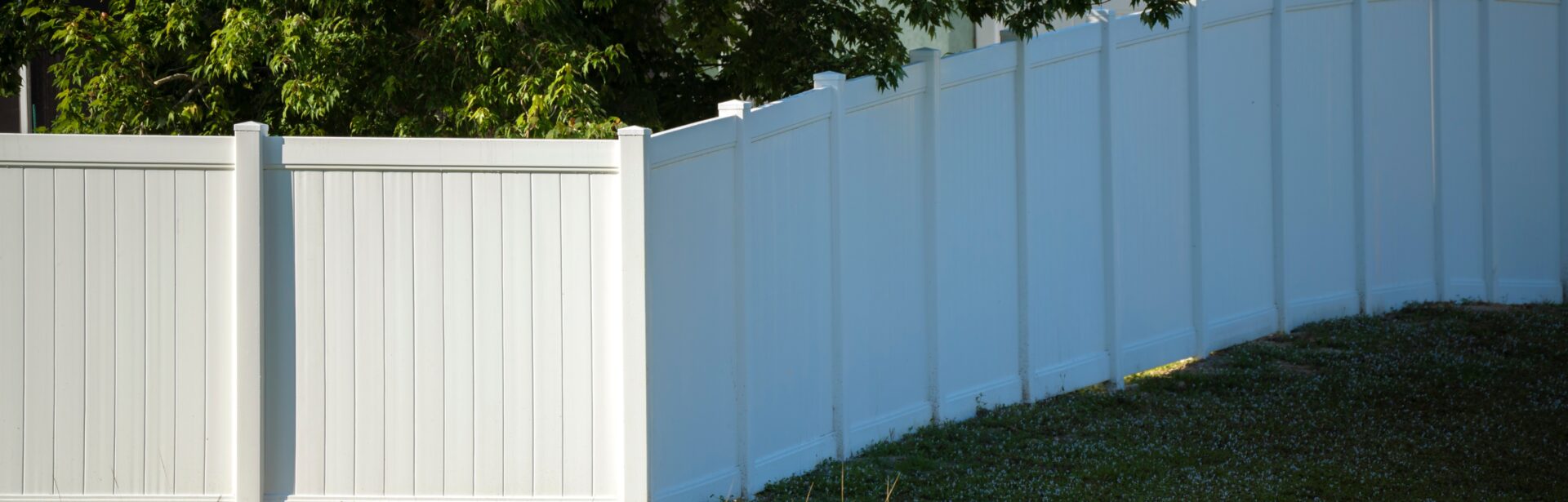 A tall white vinyl privacy fence.