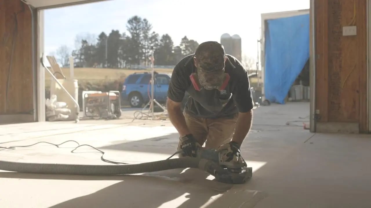 Deluxe Garages technician preparing concrete