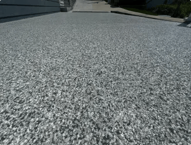 Decorative driveway concrete coating in flake finish